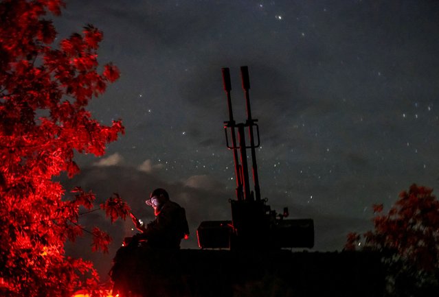 A Ukrainian serviceman from an anti-drone mobile air defence unit uses his mobile device near a ZU-23-2 anti aircraft cannon as he waits for Russian kamikaze drones, amid Russia's attack on Ukraine, in Kherson region, Ukraine on June 11, 2024. (Photo by Ivan Antypenko/Reuters)