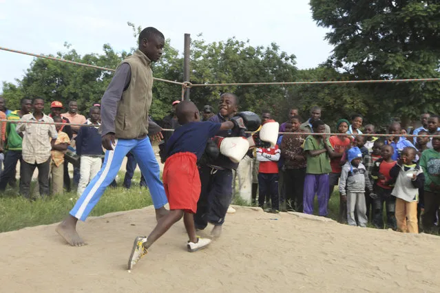 In this Sunday, March 11, 2017 photo, children fight in a boxing ring in Chitungwiza, Zimbabwe. (Photo by Tsvangirayi Mukwazhi/AP Photo)