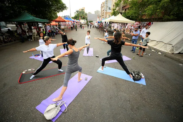 People practice yoga on a street during ongoing anti-government protests in Sidon, Lebanon on October 27, 2019. (Photo by Ali Hashisho/Reuters)