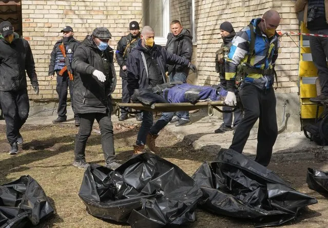 Volunteers collect bodies of murdered civilians, in Bucha, close to Kyiv, Ukraine, Monday, April 4, 2022. Russia is facing a fresh wave of condemnation after evidence emerged of what appeared to be deliberate killings of civilians in Ukraine. (Photo by Efrem Lukatsky/AP Photo)