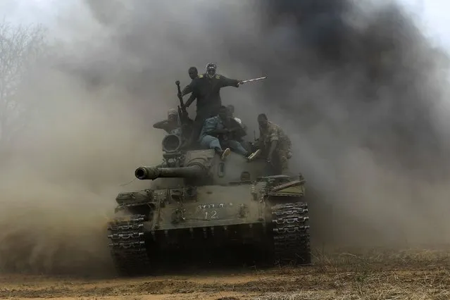 Sudanese Armed Forces (SAF) and Rapid Support Forces (RSF) personnel ride on a tank after recapturing the Daldako area, outside the military headquarters in Kadogli May 20, 2014. The SAF had recaptured the Daldako area, east of the South Kordofan state capital of Kadogli, from rebels, according to media reports quoting the SAF on Sunday. (Photo by Mohamed Nureldin Abdallah/Reuters)