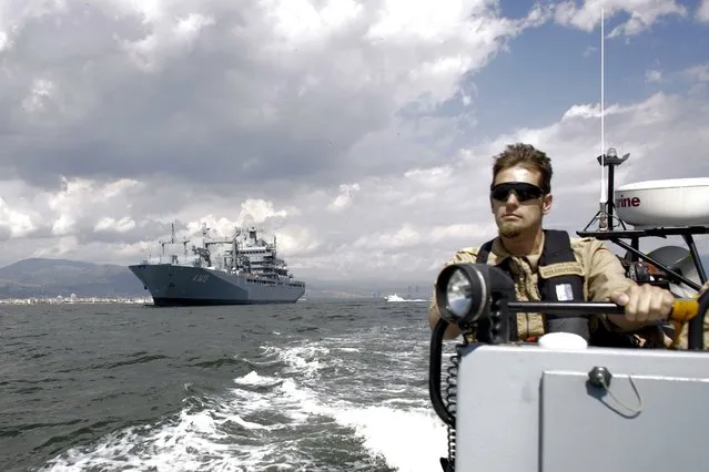 Escorted by a rescue speed boat, the NATO German warship FGS Bonn, left, departs from the harbor of the city of Izmir, Turkey, Thursday, May 26, 2016. The FGS Bonn is part of the NATO flotilla patrolling the Aegean Sea in an effort to curb migrant activity between Turkey and Greece. (Photo by Markus Schreiber/AP Photo)