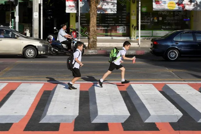 Children walk past a 3D pedestrian crossing in Bangkok, Thailand on November 28, 2019. (Photo by Chalinee Thirasupa/Reuters)