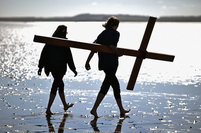 More than 50 people, young and old, celebrate Easter by crossing the tidal causeway during the annual Christian pilgrimage on March 25, 2016 in Berwick Upon Tweed, England. Every year people of all ages, from all over the world and from all realms of Christian life walk together at Easter to Holy Island. (Photo by Jeff J. Mitchell/Getty Images)
