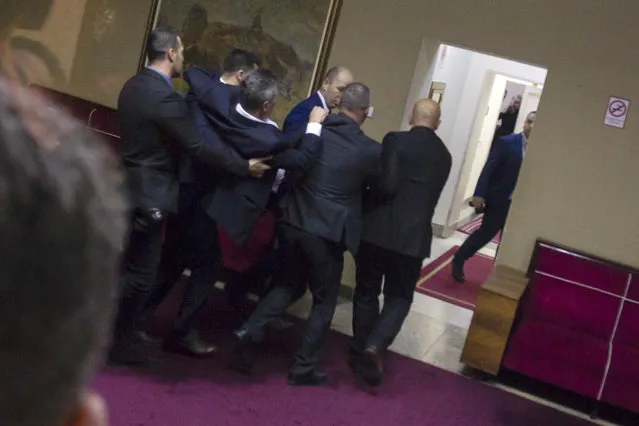 Police officers carry a pro-Serb opposition lawmaker in the parliament building in Podgorica, Montenegro, Friday, December 27, 2019. The Serbian Orthodox Church says the law will strip it of its property, including medieval monasteries and churches. The government has denied that. Montenegro's parliament adopted a contested law on religious rights after chaotic scenes in the assembly that resulted in the detention of all pro-Serb opposition lawmakers. (Photo by AP Photo)