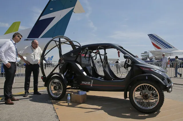 Visitors looks at the flying car Pegasus 1, built by French entrepreneur Jerome Dauffy at Paris Air Show, in Le Bourget, east of Paris, France, Tuesday, June 20, 2017. Aviation professionals and spectators are expected at this week's Paris Air Show, coming in, in a thousands from around the world to make business deals. (Photo by Michel Euler/AP Photo)