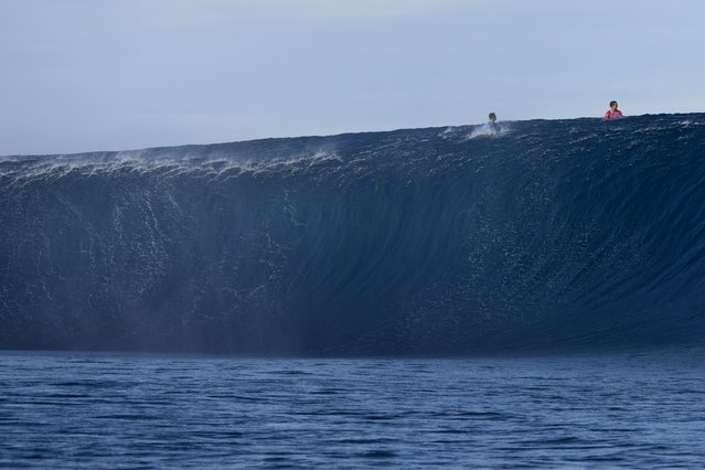 Griffin Colapinto, of the United States, right, and Kauli Vaast, of France, go over the top of a wave during the third round of surfing competition at the 2024 Summer Olympics, Monday, July 29, 2024, in Teahupo'o, Tahiti. (Photo by Gregory Bull/AP Photo)