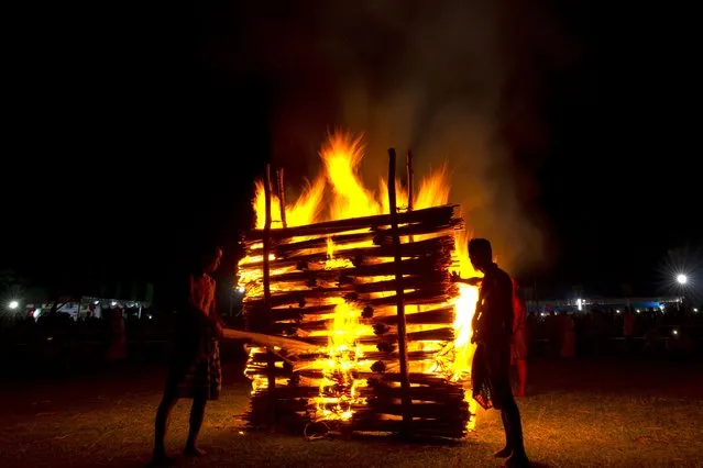 Indian Rabha tribal Hindu priests burn wood during Baikho festival at Gamerimura village along the Assam Meghalaya border, west of Gauhati, India, Saturday, June 4, 2022. (Photo by Anupam Nath/AP Photo)