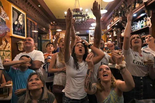 Real Madrid supporters react in a bar in Madrid during the UEFA Champions League final football match between Liverpool and Real Madrid taking place at the Stade de France in Saint-Denis, north of Paris, on May 28, 2022. (Photo by Gabriel Bouys/AFP Photo)