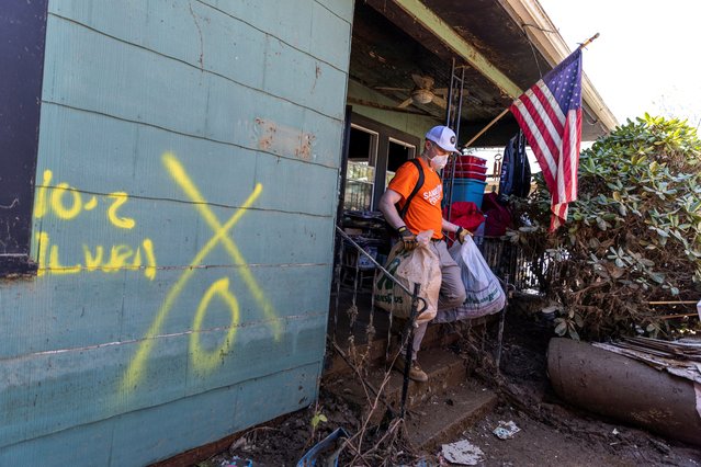 A volunteer helps to clean houses covered in mud,  following the passing of Hurricane Helene, in Swannanoa, North Carolina on October 7, 2024. (Photo by Eduardo Munoz/Reuters)