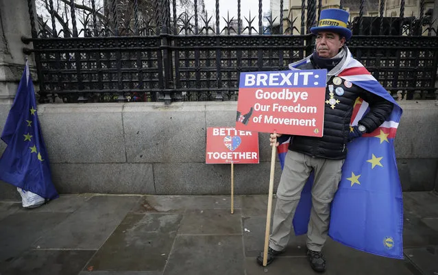 Anti-Brexit campaigner Steve Bray holds banners as he stands outside Parliament in London, Thursday, January 30, 2020. Although Britain formally leaves the European Union on Jan. 31, little will change until the end of the year. Britain will still adhere to the four freedoms of the tariff-free single market – free movement of goods, services, capital and people. (Photo by Kirsty Wigglesworth/AP Photo)