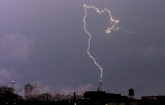 A bolt of lightening strikes near the top of the Willis tower in downtown Chicago, Monday, June 30, 2014, as rain and high winds were moving into Illinois from Iowa. Some flights are canceled at Chicago's O'Hare International Airport as northern Illinois braces for severe�weather. (Photo by Kiichiro Sato/AP Photo)