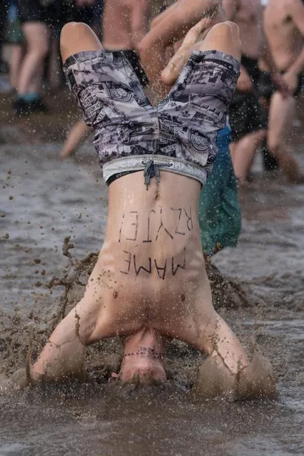 Fans bath in the mud during the “Woodstock Festival Poland” on August 3, 2017 in Kostrzyn Nad Odra, Poland. (Photo by Music/Alamy Stock Photo)