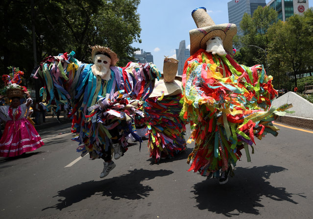 People wearing traditional costumes take part in a march to mark the International Day of the World's Indigenous Peoples, in Mexico City, Mexico on August 9, 2023. (Photo by Henry Romero/Reuters)