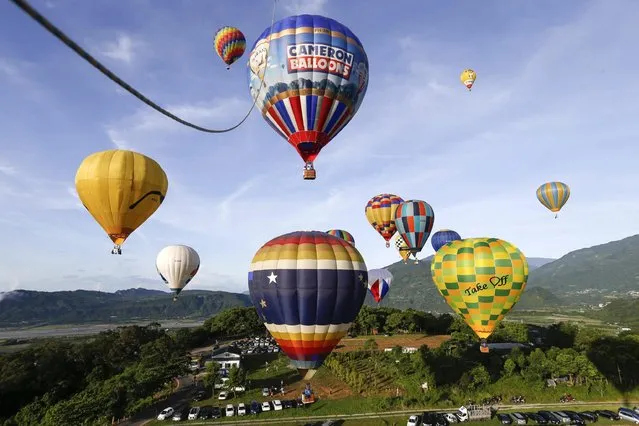 Spectators view hot air balloon during the 2016 International Hot Air Balloon Festival in Taitung, southeast of Taiwan, 01 July 2016. (Photo by Ritchie B. Tongo/EPA)