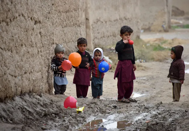 Children play with balloons along a street in Kandahar Province on January 28, 2020. (Photo by Javed Tanveer/AFP Photo)