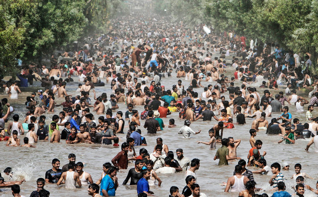 Pakistanis swim in a canal to cool off as temperatures reached 44 degrees Celsius (111F), in Lahore, Pakistan, on June 17, 2012. (Photo by K.M. Chaudary/AP Photo)