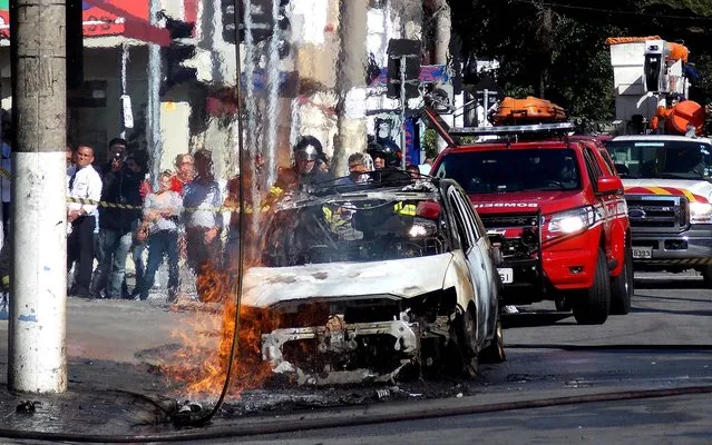 Dangling high tension electric wire fell on the car and caused the fire at Rua João Cachoeira, in Itaim Bibi, south of São Paulo, on August 21, 2014. (Photo by Alexandre Serpa/Futura Press/Estadão Conteúdo)