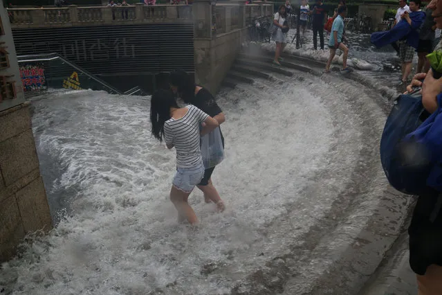 People walk into a flooded subway station in Tianjin, China, July 20, 2016. Picture taken July 20, 2016. (Photo by Reuters/Stringer)