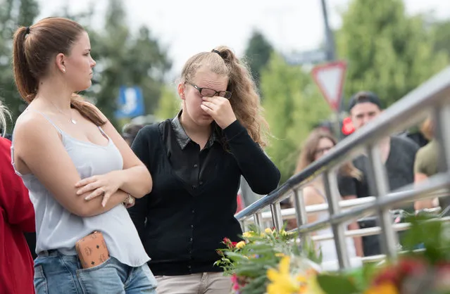 A woman cries at a make shift memorial site near the Olympia shopping center where a shooting took place leaving nine people dead the day before on Saturday, July 23, 2016 in Munich, Germany. (Photo by Sebastian Widmann/AP Photo)