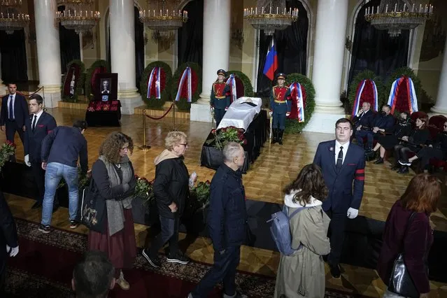 People walk past the coffin of former Soviet President Mikhail Gorbachev inside the Pillar Hall of the House of the Unions during a farewell ceremony in Moscow, Russia, Saturday, Sept. 3, 2022. Gorbachev, who died Tuesday at the age of 91, will be buried at Moscow's Novodevichy cemetery next to his wife, Raisa, following a farewell ceremony at the Pillar Hall of the House of the Unions, an iconic mansion near the Kremlin that has served as the venue for state funerals since Soviet times. (Photo by Alexander Zemlianichenko/AP Photo)