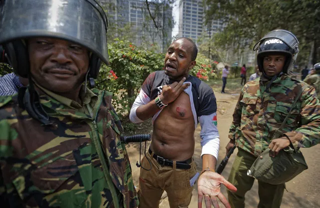 Prominent Kenyan activist Boniface Mwangi complains to a senior police officer after his men shot Mwangi in the chest with a tear gas grenade, at a demonstration against police killings of protesters and opposition supporters, in downtown Nairobi, Kenya Thursday, October 19, 2017. (Photo by Ben Curtis/AP Photo)
