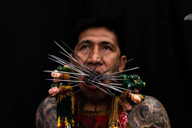 A medium man with his mouth pierced is portrayed while in trance during the Kathu Shrine procession amidst celebrations of the annual vegetarian festival, observed by Taoist devotees from the Thai-Chinese community in the ninth lunar month of the Chinese calendar, in Phuket Town, Thailand on October 3, 2022. (Photo by Jorge Silva/Reuters)