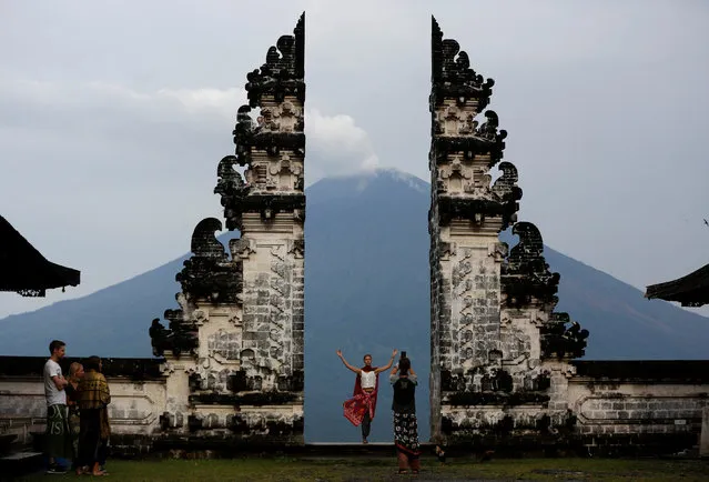Tourists visit Lempuyang temple which overlooks Mount Agung volcano, in Karangasem Regency, Bali, Indonesia, December 3, 2017. (Photo by Darren Whiteside/Reuters)