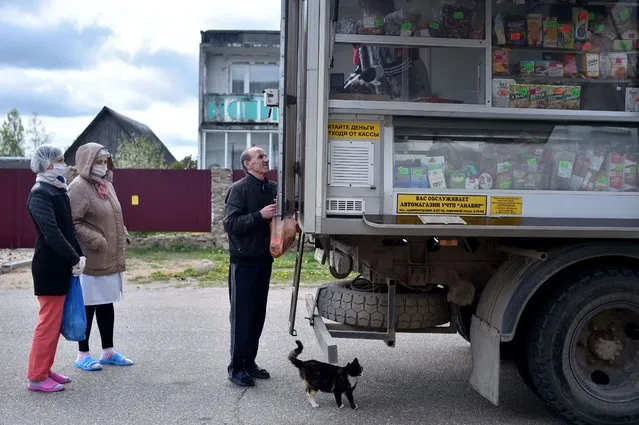 A patient of a social shelter buys food from a truck transformed into a mobile shop in the village of Kreva, some 100 km northwest of Minsk, on May 14, 2020, amid the coronavirus pandemic. (Photo by Sergei Gapon/AFP Photo)
