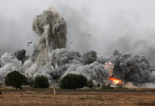 In this Sunday, October 12, 2014 file photo, thick smoke, debris and fire rise following an airstrike by the US-led coalition in Kobani, Syria as fighting intensified between Syrian Kurds and the militants of Islamic State group, as seen from Mursitpinar on the outskirts of Suruc, at the Turkey-Syria border. (Photo by Lefteris Pitarakis/AP Photo)