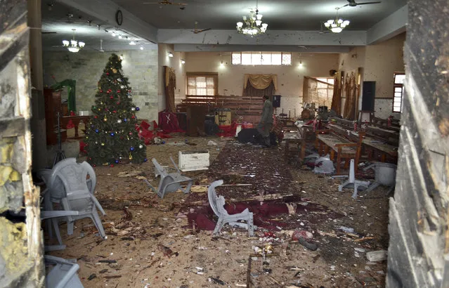 A Pakistani walks in the main hall of a church following a suicide attack in Quetta, Pakistan, Sunday, December 17, 2017. Two suicide bombers attacked the church when hundreds of worshippers were attending services at the church ahead of Christmas. (Photo by Arshad Butt/AP Photo)
