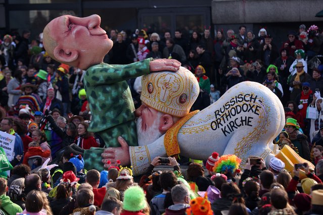 People stand around a carnival float depicting Russian President Vladimir Putin and the Russian Orthodox Church, at the traditional “Rosenmontag” Rose Monday carnival parade in Dusseldorf, Germany, on February 12, 2024. (Photo by Thilo Schmuelgen/Reuters)