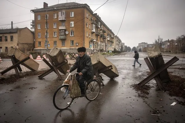 A resident rides his bike through street barricades on December 13, 2022  in Bakhmut, Ukraine. Russia continues its campaign to seize Bakhmut, Donetsk region, in what many analysts regard as an offensive with more symbolic value than operational importance for Russia. In a recent intelligence report, the British ministry of defense said Russia would try to encircle the city. (Photo by Chris McGrath/Getty Images)