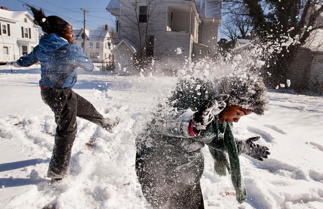 Satoria Ginn throws snow at Desiree Lyons  along Laurel Street in Pocomoke City, Maryland, January 24, 2013. The snow was very dry, making snowballs hard to make, so they settled for throwing snow at each other. (Photo by Grant L. Gursky/The Daily Times)