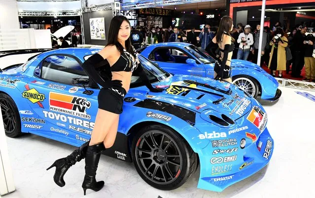 Models pose beside RE Amemiya FD3 S RX-7 cars at the RE Amemiya booth of the Tokyo Auto Salon at the Makuhari Messe in Chiba on January 12, 2018. The exhibition, one of the largest annual custom cars and its related products show, runs this year from January 12-14. (Photo by Toshifumi Kitamura/AFP Photo)