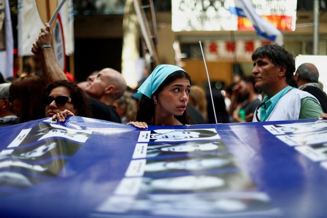 Demonstrators hold a banner with images of missing persons, victims of Argentina's last dictatorship, as they arrive at Plaza de Mayo square to mark the 48th anniversary of the 1976 military coup, in Buenos Aires, Argentina March 24, 2024. (Photo by Matias Baglietto/Reuters)