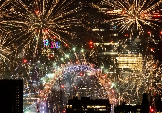 A firework display heralds the New Year in central London on January 1, 2023. London is hosting a firework spectacular at midnight to herald the New Year on the River Thames for the first time since the start of the pandemic. (Photo by Peter Macdiarmid/London News Pictures)