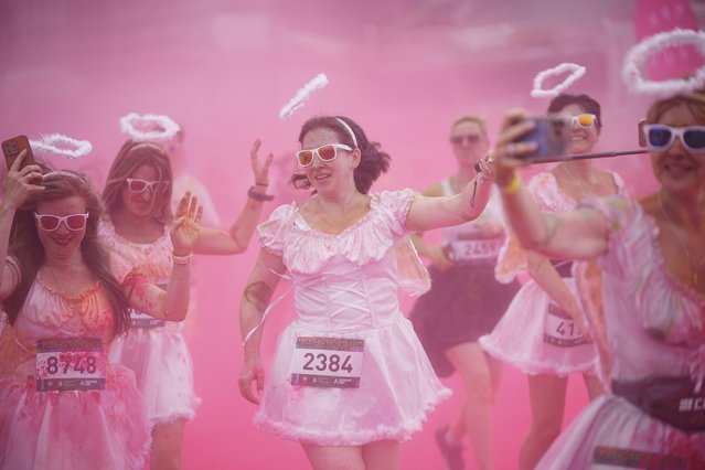 Participants get covered with colored powder during The Color Run in Moscow, Russia, Sunday, June 8, 2025. (Photo by Pavel Bednyakov/AP Photo)