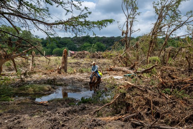 An Ingram Fire Department officer performs a search and rescue operation on horseback on July 12, 2025 in Hunt, Texas. More than 160 people are still missing after storm cells halted over the area, dumping nearly 15 inches of rain and causing a 22-foot rise along the Guadalupe River. (Photo by Brandon Bell/Getty Images)