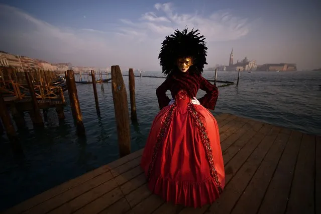 A masked reveller wearing a traditional carnival costume poses in St Mark Square during Venice's Carnival on January 28, 2018. (Photo by Filippo Monteforte/AFP Photo)
