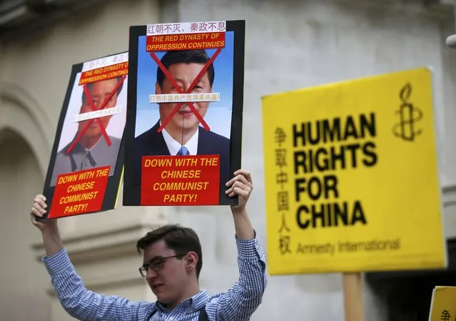 Human rights protesters hold up placards as they wait for China's President Xi Jinping to pass on the Mall during his ceremonial welcome, in London, Britain, October 20, 2015. (Photo by Peter Nicholls/Reuters)