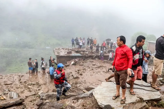 Rescue workers and residents gather for search at the scene of a landslide following heavy rains in Bahrabise municipality of Sindhupalchok district, some 90 kms northeast of Kathmandu on September 13, 2020. (Photo by Niroj Chaoulagain/AFP Photo)