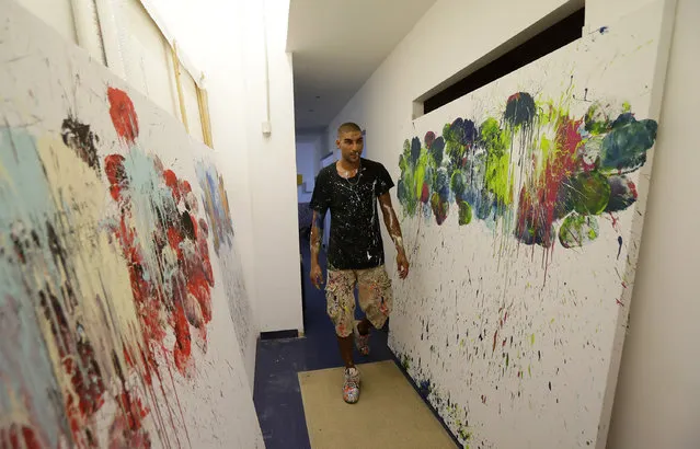 In this photo taken on Tuesday, September 6, 2016 Omar Hassan walks past his creations “Breaking Through” in his studio in Milan, Italy. (Photo by Antonio Calanni/AP Photo)