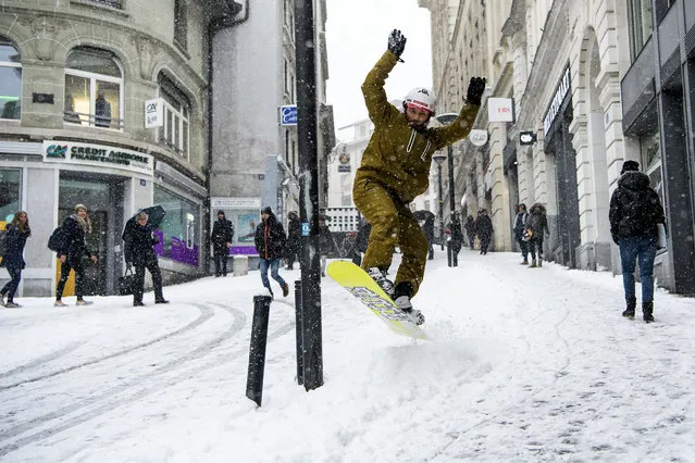 Sylvain rides a snow-covered street named 'rue du petit chene' with his snowboard during a snowfall in Lausanne, Switzerland, 01 March  2018. Media reports state that extreme cold weather is forecast to hit many parts of Europe with temperatures plummeting to a possible ten year low. (Photo by Jean-Christophe Bott/EPA/EFE)