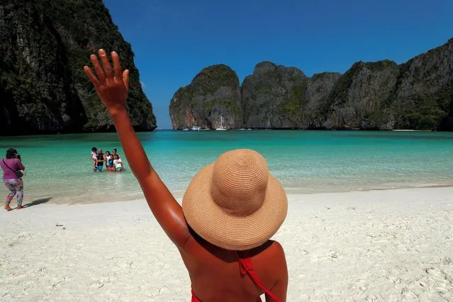 Tourists visit Maya Bay as Thailand reopens its world-famous beach after closing it for more than three years to allow its ecosystem to recover from the impact of over tourism, at Krabi province, Thailand on January 3, 2022. To ensure it remains protected, authorities said only up to 375 visitors will be allowed to visit at one time and swimming will be prohibited for now. Boats will only be allowed to dock at a designated location at the back of the bay to avoid damaging coral reefs, they said. (Photo by Jorge Silva/Reuters)