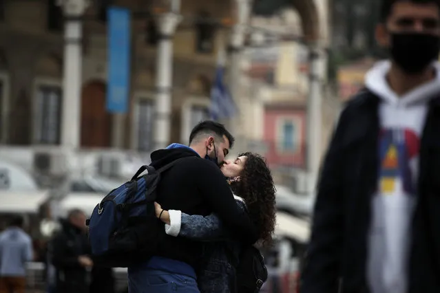 A couple kiss each other in Athens, Friday, November 6, 2020. With a surge in coronavirus cases straining health systems in many European countries, Greece announced a nationwide lockdown. The lockdown takes effect at daybreak on Saturday across the country and will last until the end of the month. (Photo by Thanassis Stavrakis/AP Photo)