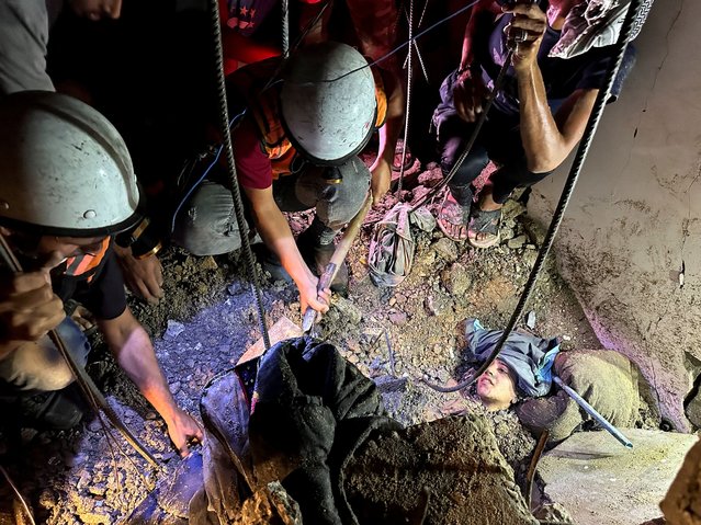 Rescuers try to free a Palestinian woman trapped under the rubble of a house hit by an Israeli strike in Nuseirat, Gaza Strip on August 20, 2025. (Photo by Reuters/Stringer)