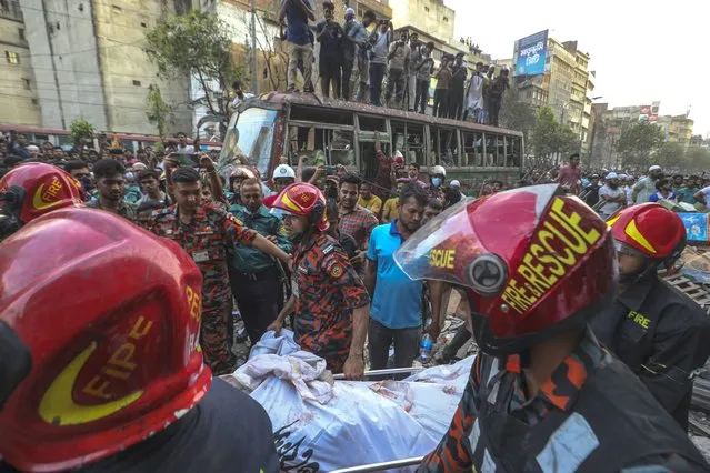Fire officials carry a body of a victim after an explosion in a commercial building, in Dhaka, Bangladesh, Tuesday, March 7, 2023. (Photo by Abdul Goni/AP Photo)