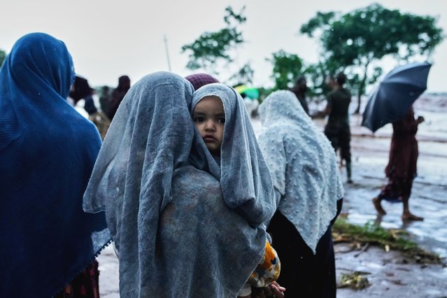A girl carries a baby while waiting for their relatives during rescue operations, as residents evacuate their homes and move to safer areas after the River Chenab overflowed due to heavy rainfall, breaching the danger mark at Village Garkhal in Akhnoor, India, Wednesday, September 3, 2025. (Photo by Channi Anand/AP Photo(