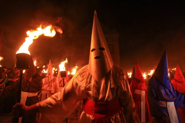 Hooded people participate in the centenary Fogareu procession during the early morning hours in Goias, Brazil, 29 March 2018. With almost three centuries of tradition, the procession of the Fogareu marked the beginning of Holy Thursday in Brazil. (Photo by Weimer Carvalho/EPA/EFE)